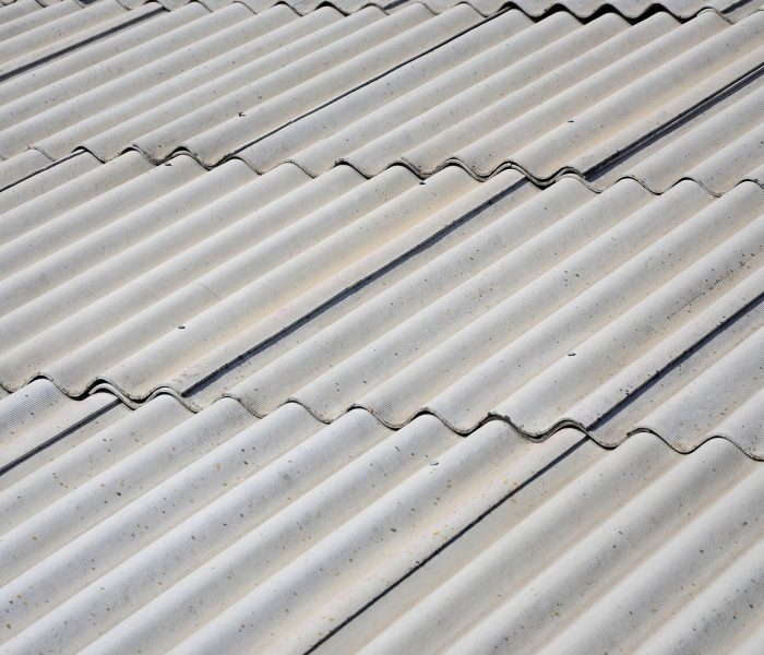 A fragment of a gray slate roof of an old sample made of asbestos material